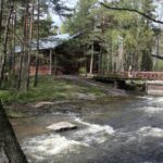 Kuvassa kävelysilta vuolaasti virtaavan kosken yli. Taustalla keisarillinen kalastusmaja. Kuva: Evgeni Usov