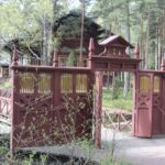 Kuvassa iso puinen portti. Ovet auki.Taustalla talo. Keisarillinen kalastusmaja. Kuva: Evgeni Usov