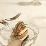 Dish with Baltic herring and potato. The dish is assembled on an old glass plate.