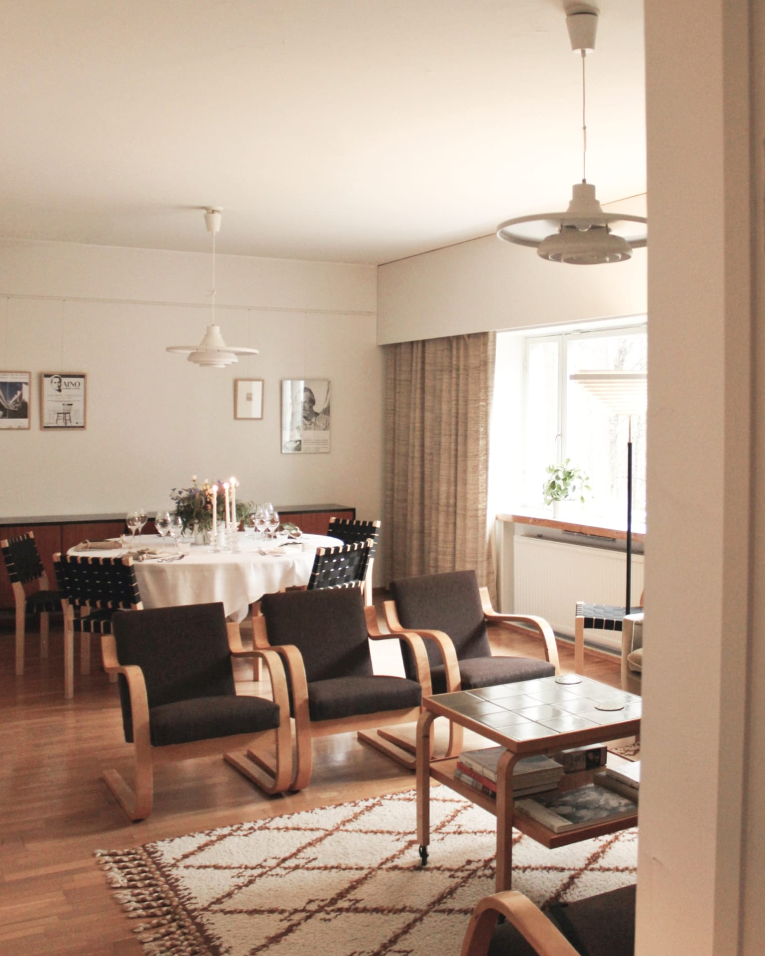 Kantola lounge with round dinner table and artek armchairs, lamps and sofa.